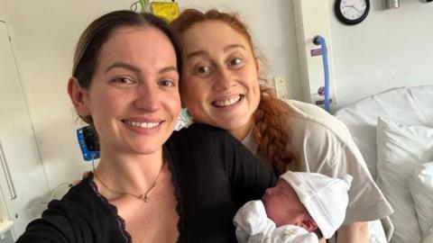 Georgia holding a newborn baby and Daisy