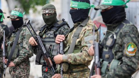 Gunmen stand guard at the funeral of Hamas's deputy military chief Marwan Issa, who was killed in an Israeli air strike, in the central Gaza Strip (7 February 2025)
