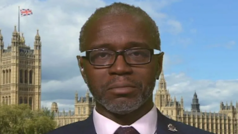 Inspector Tola Munro wearing his police uniform in an interview in front of the Houses of Parliament. 