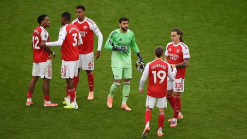 Arsenal players chat before a game on the pitch
