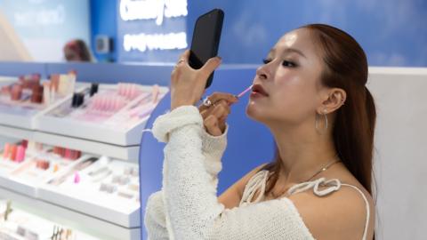 A woman putting on make-up at K-beauty store PureSeoul in central London