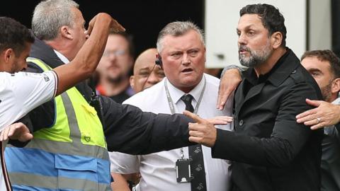 Cardiff boss Erol Bulut and Swansea's Kyle Naughton are separated by stewards following an argument