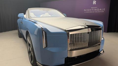 A light blue Rolls-Royce two-seat convertible inside a showroom. 