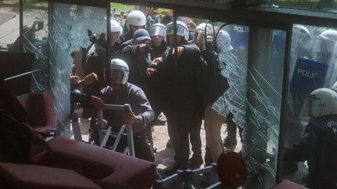 Riot police fire tear gas as they break the entrance door of the party’s headquarters on May 24, 2026 in Ankara, Turkey.