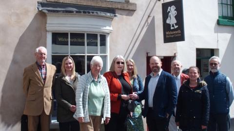 Group of people posing for photo outside heritage centre building