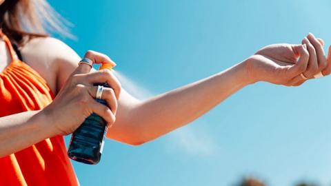 Woman applying sunscreen