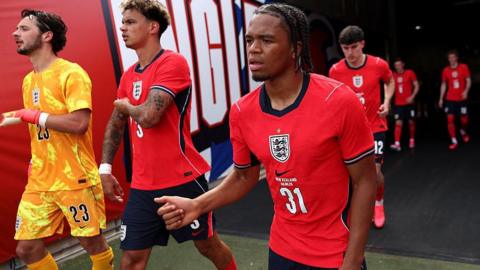 Ngumoha, wearing a red England shirt, walks out of the tunnel for the second half of their game against New Zealand