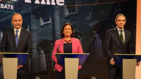 Michael Martin, Mary Lou McDonald and Simon Harris all stand at the podium during the debate