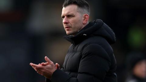 Luton Town manager Matt Bloomfield applauds fans after the defeat by Millwall