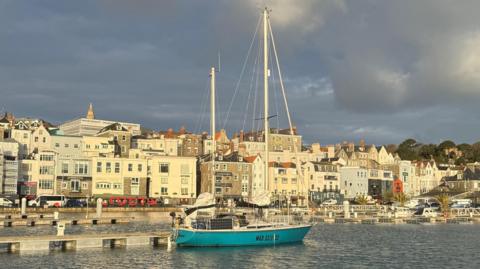A blue yacht in St Peter Port harbour
