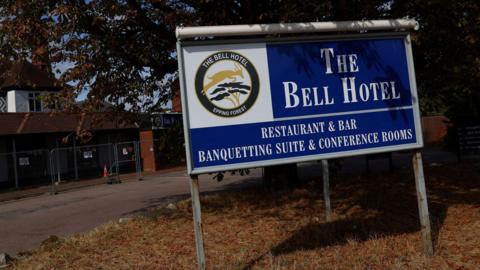 A sign that reads The Bell Hotel on a blue sign 
