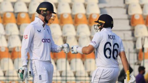 Zak Crawley and Joe Root punch gloves