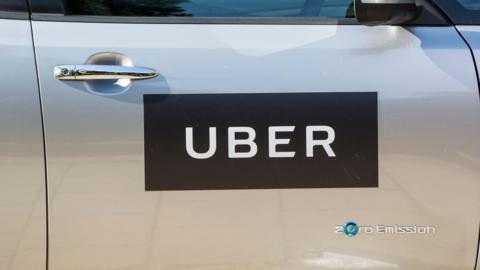Generic image of the side of a silver car with an UBER sticker stuck on the side.
