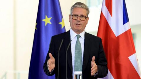 Keir Starmer, UK prime minister, during a news conference standing in front of the EU and Union Jack flags.