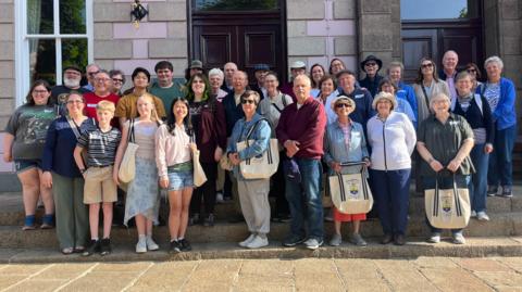Thirty members of the Poindexter Descendants Association standing on the steps of Jersey's Royal Court.