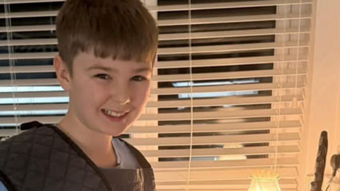 Harvey, 12, standing in the kitchen and looking into the camera smiling