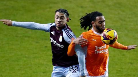 Aston Villa's Luka Lynch (left) and Blackpool's Dominic Thompson battle for the ball 