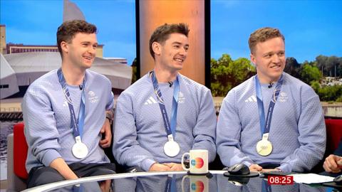 Bruce Mouat, Grant Hardie and Bobby Lammie wears their Olympics silver medals on blue ribbons, with pale blue sports sweatshirts