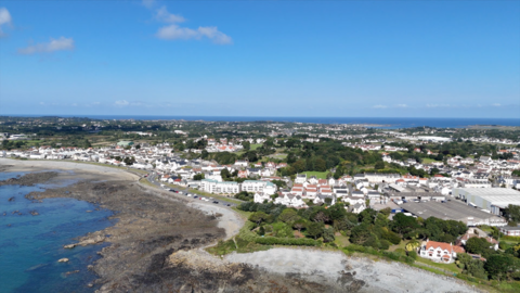 An aerial view of the Guernsey coast, showing beaches and buildings