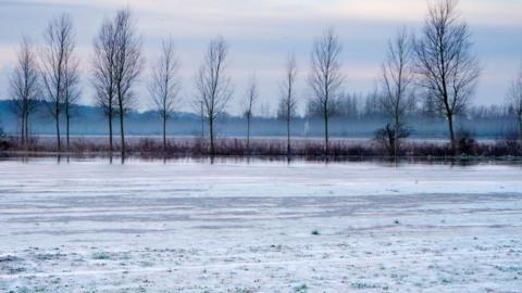 A lake iced over in cold weather.