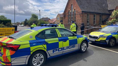 Police parked by a cordon
