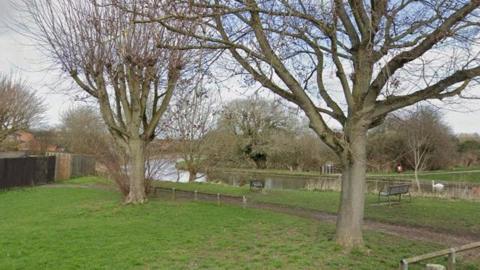 Green lawned area with water running through.