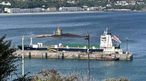 MV Arrow berthed alongside the Victoria Pier in Douglas with the Tower of Refuge in the background.