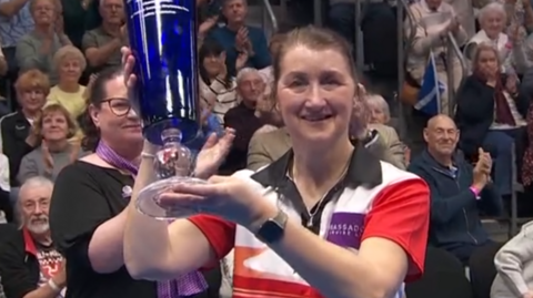 Julie Forrest lifts the women's matchplay singles trophy at the World Indoor Bowls Championships