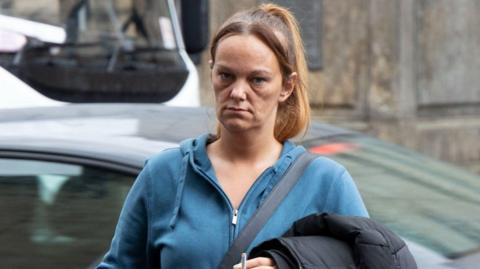 Kimberley Dow outside the High Court in Edinburgh. She has a blue top on and a cigarette in her hand.