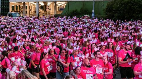 People in pink lined up at the start of the Sparkle Night Walk
