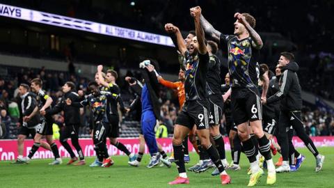 Leeds United players celebrate Premier League safety after draw against Tottenham