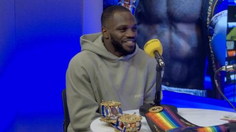 Boxer Ishmael Davis in a BBC Radio Leeds studio with the Commonwealth and British boxing belts in front of him