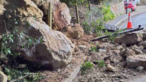 Large rocks and a traffic cone in Gills Cliff Road