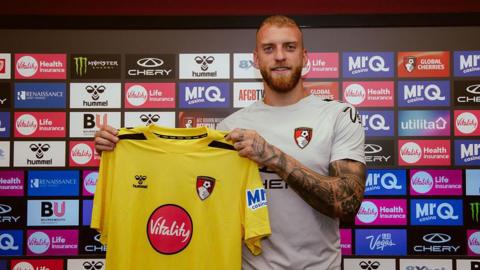 Michele di Gregorio holding up a Bournemouth goalkeeper shirt