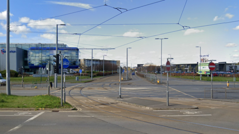 A junction at the entrance to a street with a tram line running through it