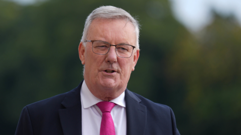 Mike Nesbitt in navy suit and pink tie