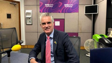 MP James Cartlidge wearing a navy suit during a visit to the ˿ Radio Suffolk studio in Ipswich.