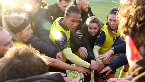 Oxford United doing a huddle with hands in
