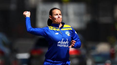 Erin Osborne throwing her hand up to bowl during a match for ACT Meteors