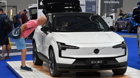 Visitors view an all electric Volvo EX30 EV SUV at the British Motor Show 2024.