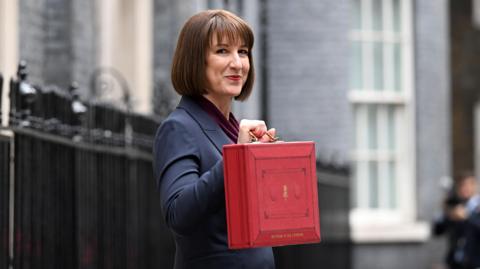 Rachel reeves holding the red budget suitcase outside 10 downing street