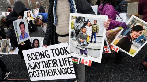 Families and friends who lost loved ones in the March 10, 2019, Boeing 737 Max crash in Ethiopia, hold a memorial protestwitha sign saying Boeing took away their life, DOJ their voice in front of the Boeing headquarters in Arlington, Virginia, on March 10, 2023 to mark the four-year anniversary of the event