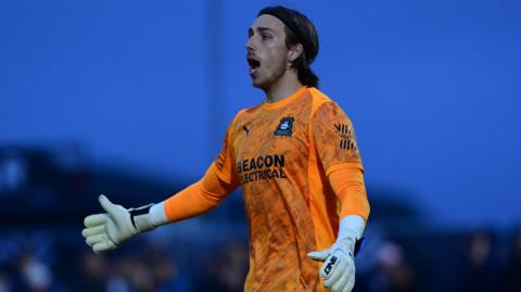 Luca Ashby-Hammond holds his arm out as he talks during a pre-season game for Plymouth