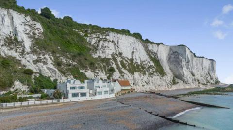 A wide shot of the 1920s white art deco style Mermaid Cottage perched underneath the White Cliffs at St Margaret's Bay