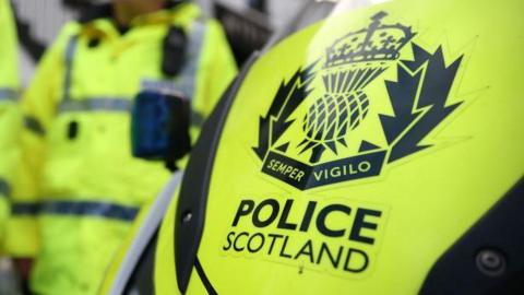 A yellow police vehicle with the words 'POLICE SCOTLAND ' in bold.