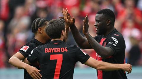 Bayer Leverkusen players celebrate in the win against Augsburg