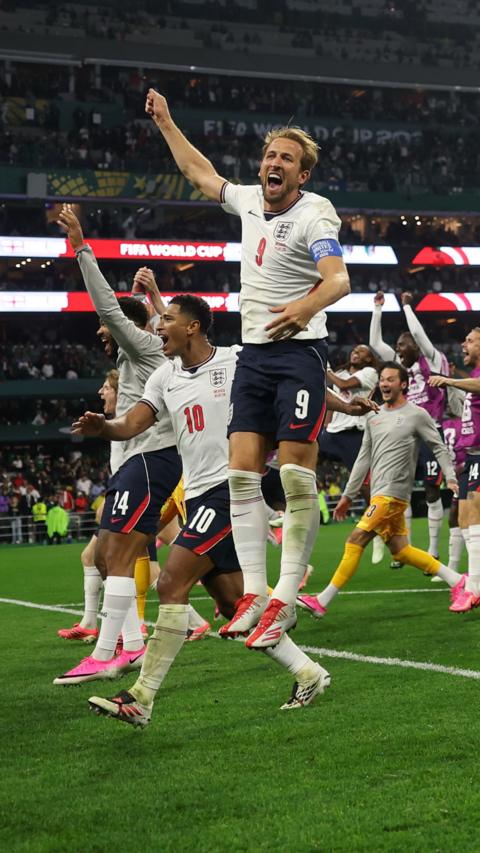 England players in kit on pitch celebrate victory