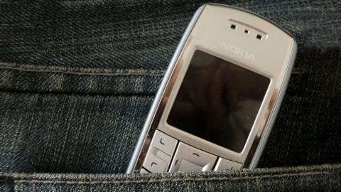 A Nokia mobile phone sitting in someone's jean pocket