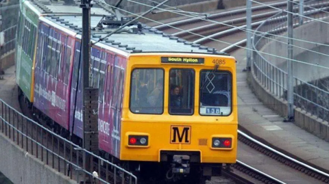 Yellow Metro train moving on the tracks. It says "South Hylton". 