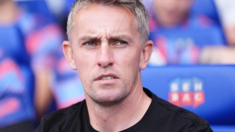 Kieran McKenna sits in the Ipswich dugout